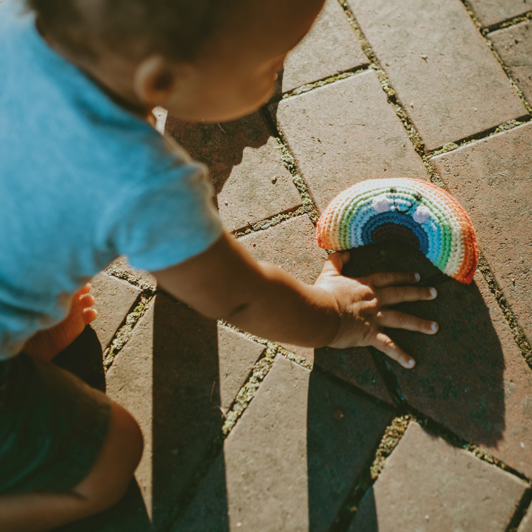 Little boy with rainbow rattle